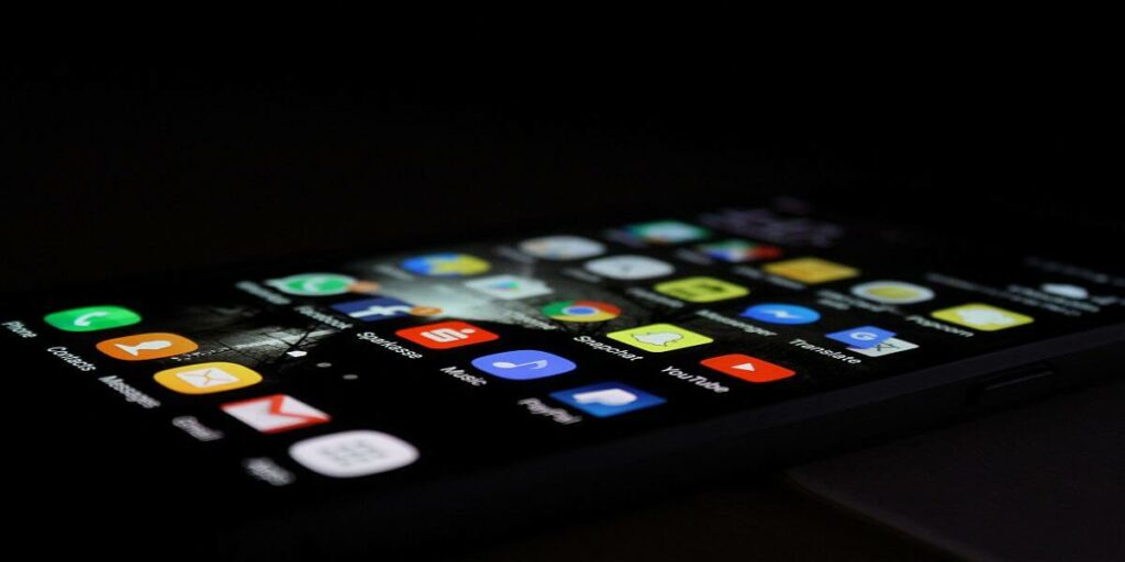 Zdjęcie przedstawia telefon z wyświetlonymi na ekranie ikonami portali społecznościowych